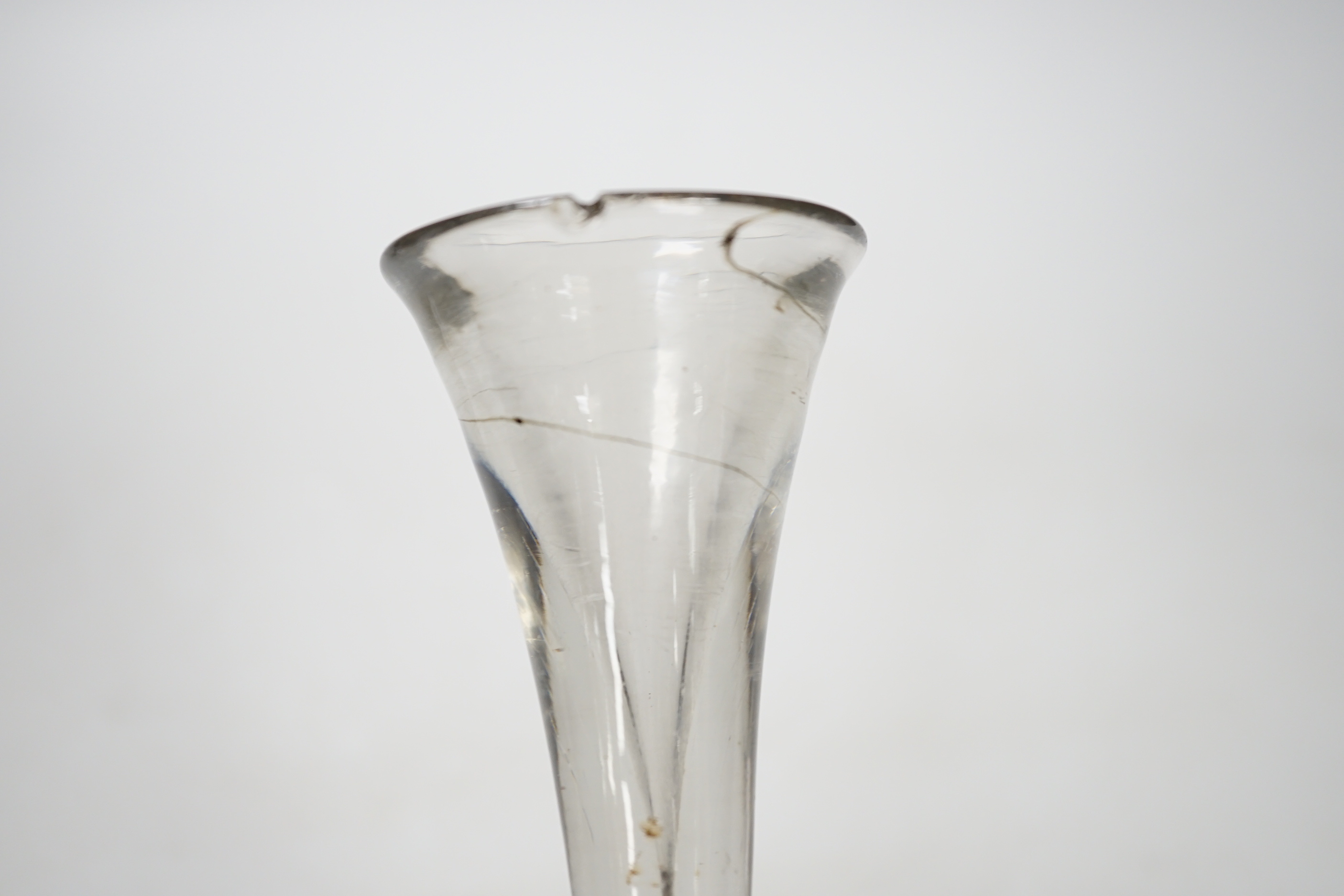 An English lead crystal baluster toastmaster’s glass, c.1710-20, elongated trumpet deceptive bowl on triple flattened annular knop, plain teared section includes a basal knop, conical folded foot, 15cm high